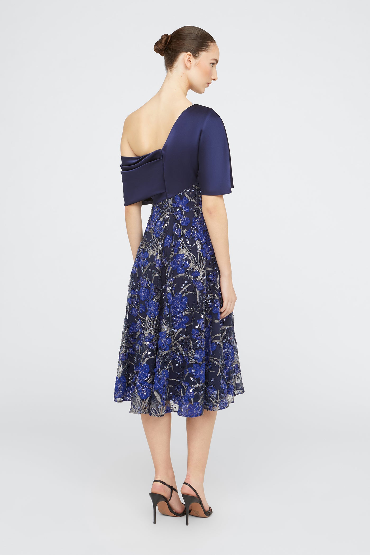 Woman wearing a blue dress with a floral pattern on a white background