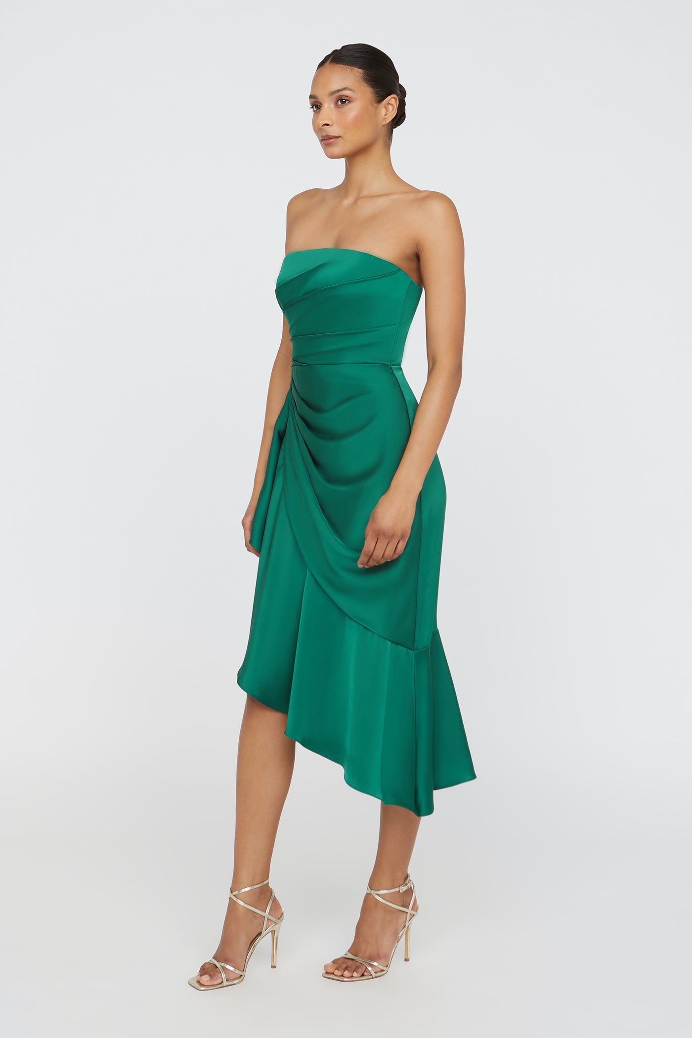 Woman wearing a green strapless dress on a white background