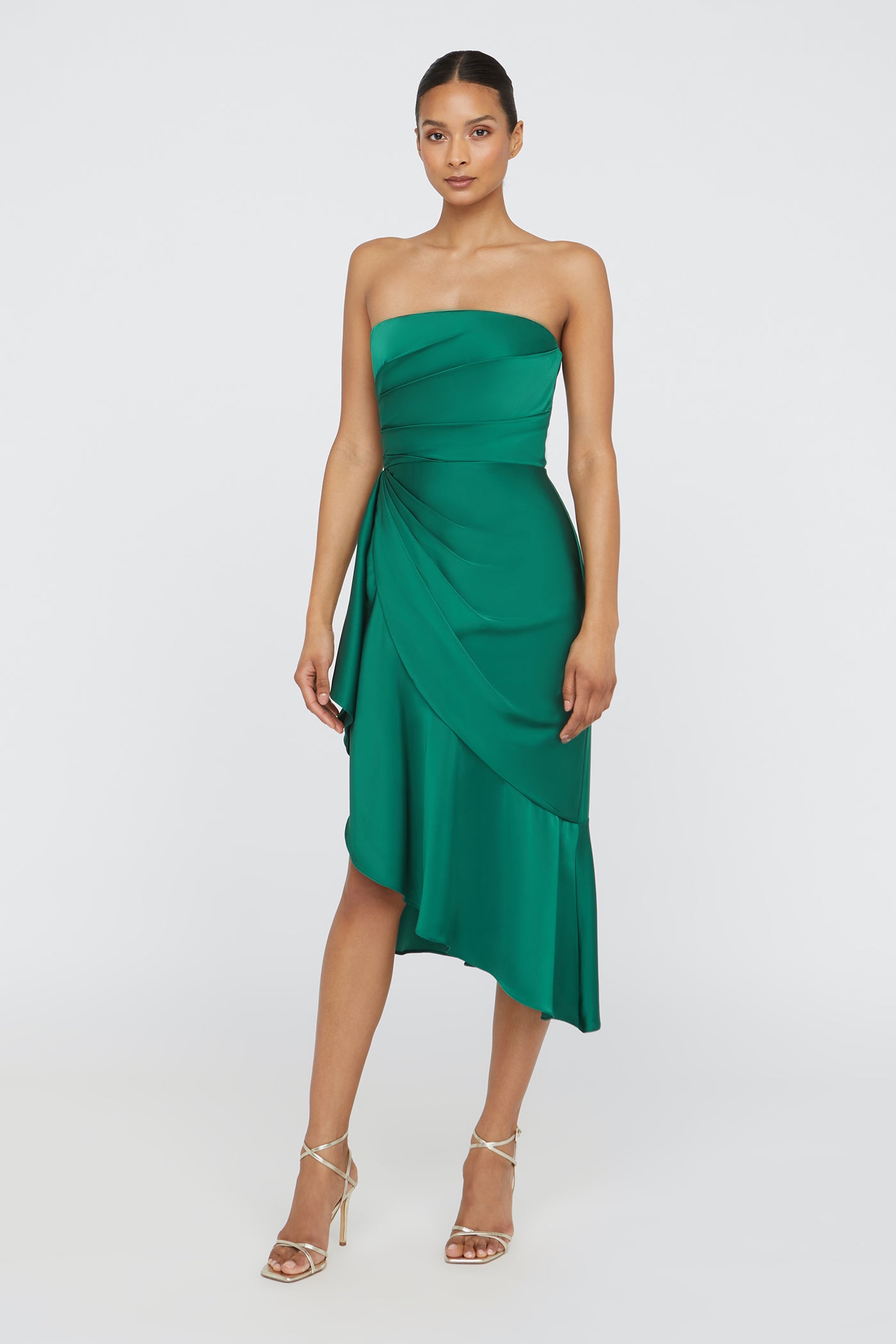 Woman wearing a green strapless dress on a white background