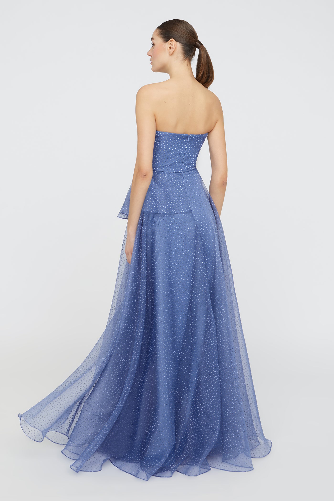 Woman wearing a blue strapless gown on a white background