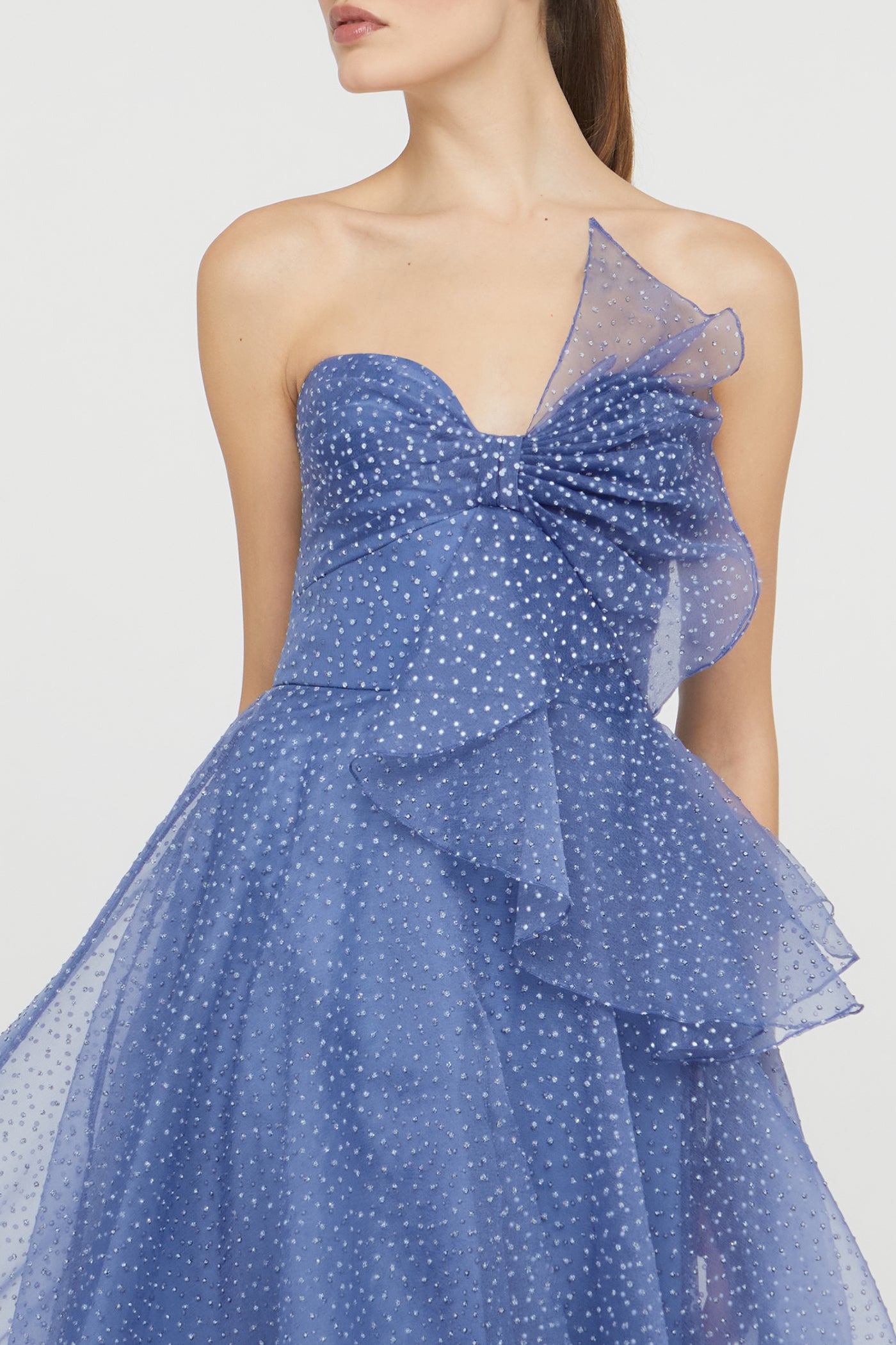 Blue polka dot dress with a bow detail on a white background