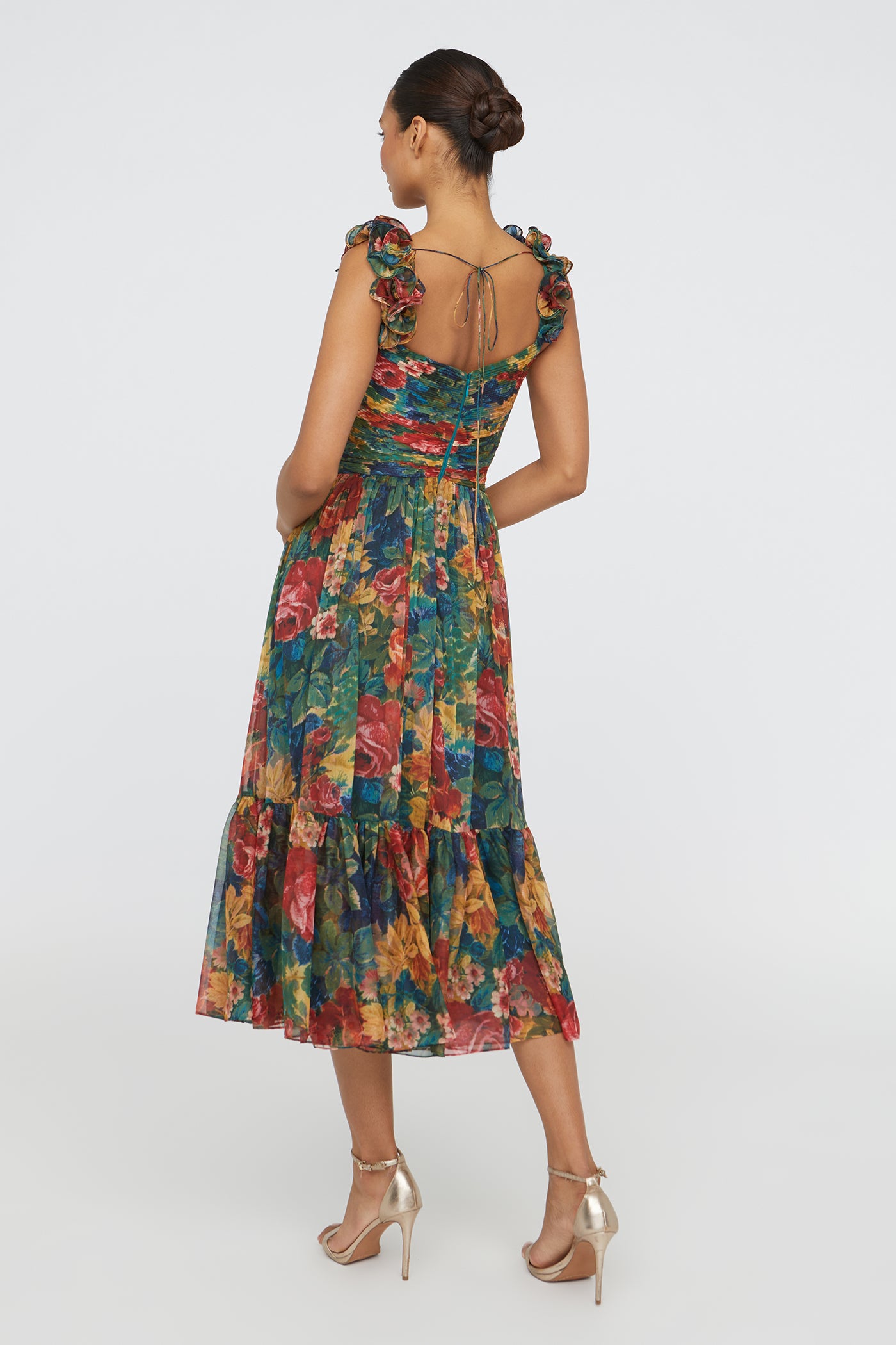Woman wearing a colorful floral dress on a white background