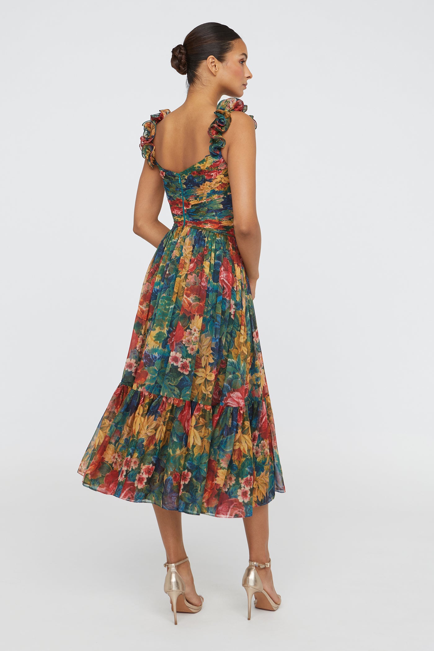 Woman wearing a colorful floral dress on a white background