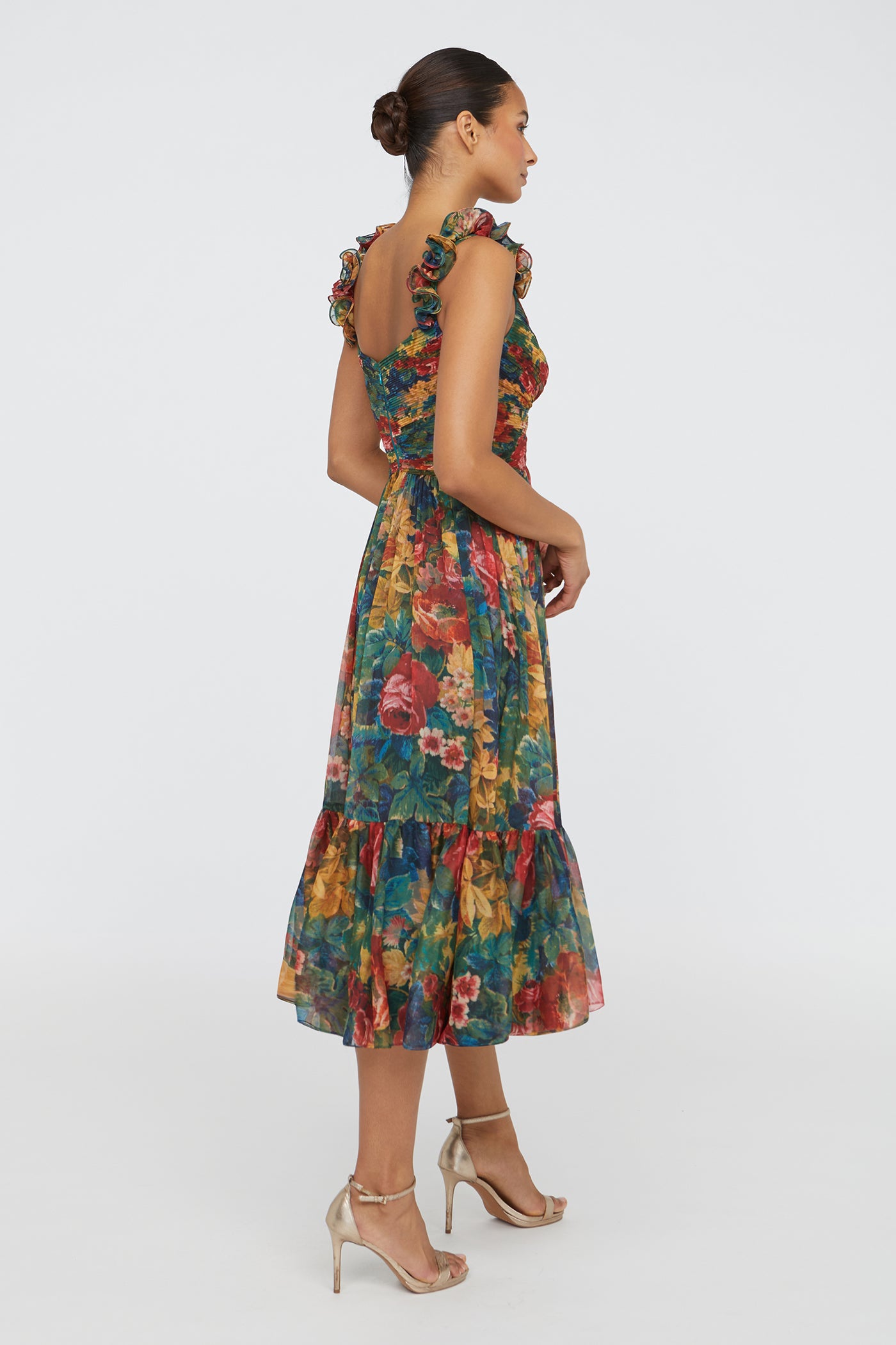 Woman wearing a colorful floral dress on a white background