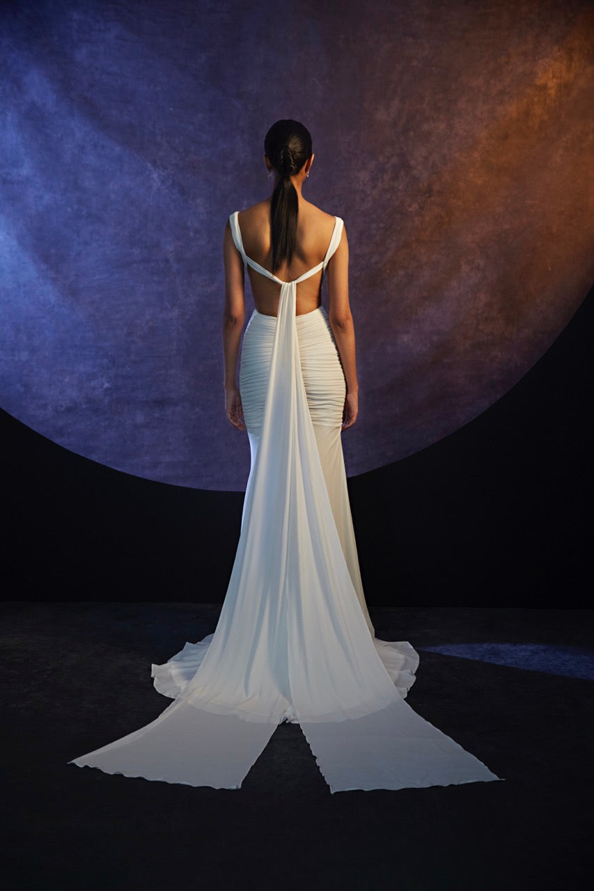 Plunging v-neck ruched stretch knit gown with cut outs and dramatic knotted watteau